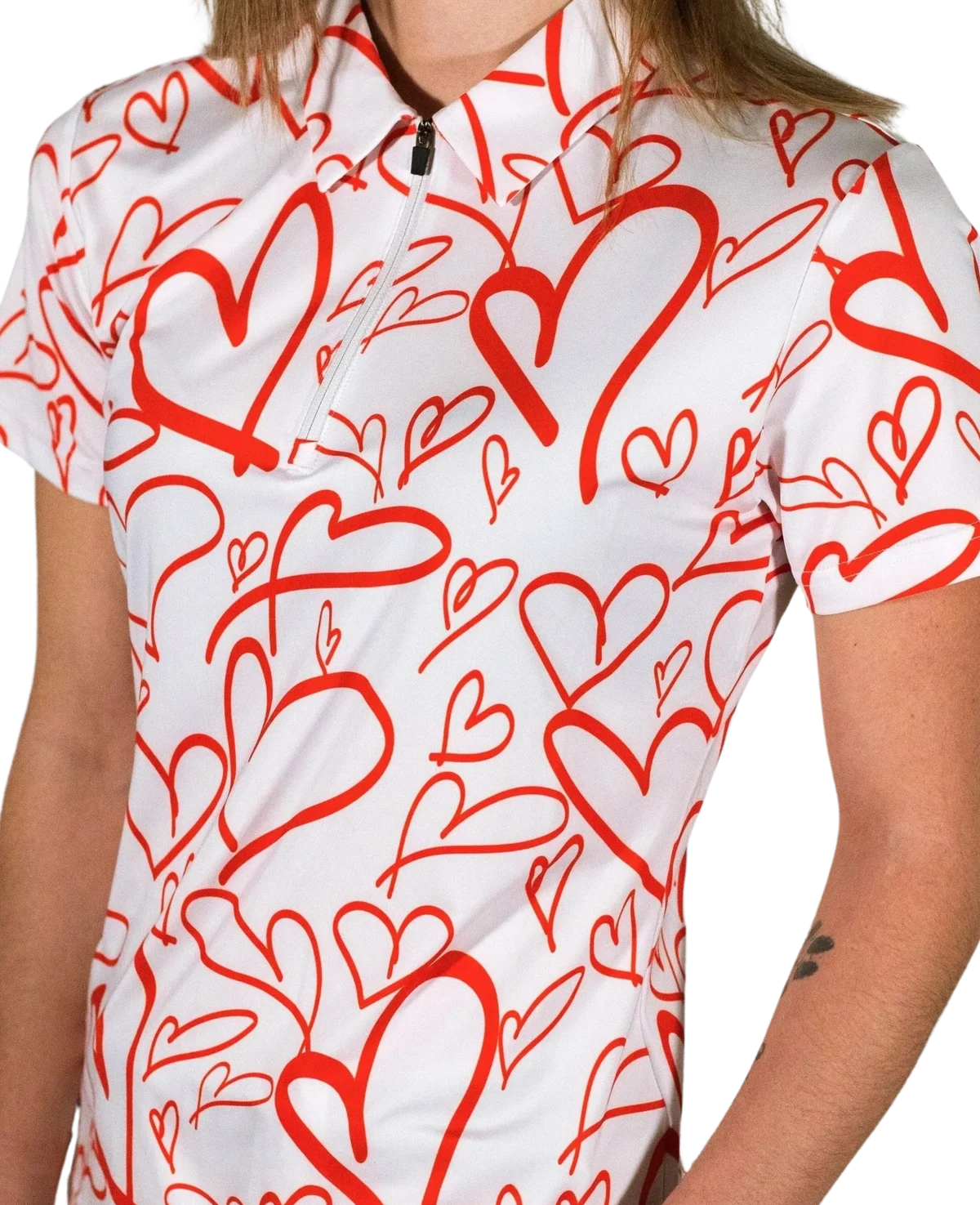 Person wearing a white T-shirt with red heart patterns.